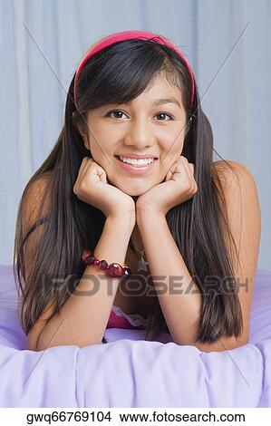 Portrait of a teenage girl lying on the bed and smiling View Large Photo Image Picture - Portrait of a teenage girl lying on the bed and smiling. Fotosearch