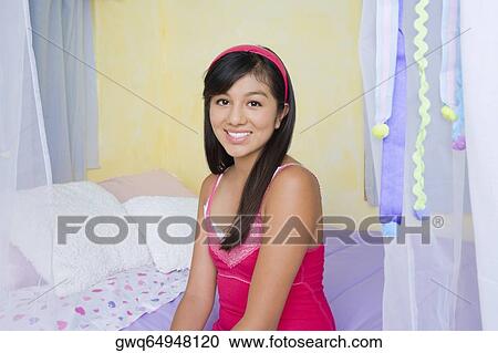 Portrait of a teenage girl sitting on the bed and smiling View Large Photo Image Stock Image - Portrait of a teenage girl sitting on the bed and smiling. Fotosearch