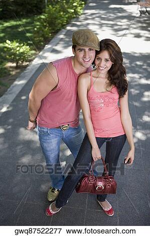 Stock Photo - Portrait of a young couple standing together and smiling. Fotosearch