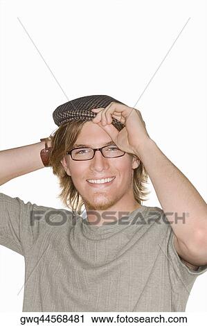 Portrait of a young man adjusting his flat cap and smiling View Large Photo Image Stock Image - Portrait of a young man adjusting his flat cap and smiling. Fotosearch