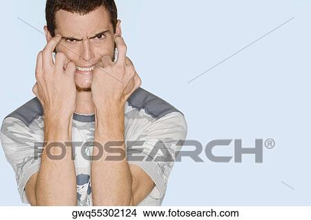 Picture - Portrait of a young man gesturing and making his face. Fotosearch