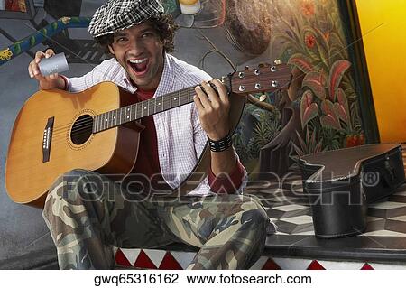 Portrait of a young man holding a guitar and a credit card View Large Photo Image Stock Image - Portrait of a young man holding a guitar and a credit card. Fotosearch