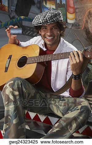 Portrait of a young man holding a guitar and a credit card View Large Photo Image Stock Photography - Portrait of a young man holding a guitar and a credit card. Fotosearch