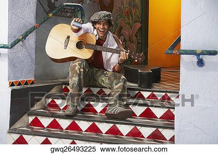 Stock Photography - Portrait of a young man holding a guitar and a credit card. Fotosearch