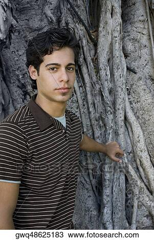 Portrait of a young man in front of a tree View Large Photo Image Stock Image - Portrait of a young man in front of a tree. Fotosearch