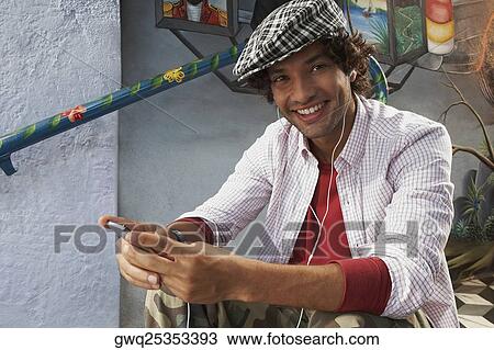 Portrait of a young man listening to music and smiling View Large Photo Image Stock Image - Portrait of a young man listening to music and smiling. Fotosearch