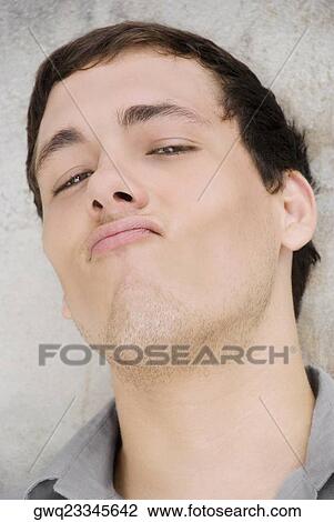 Portrait of a young man making a face View Large Photo Image Stock Image - Portrait of a young man making a face. Fotosearch