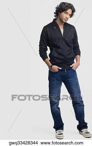 Portrait of a young man standing with his hands in his pockets View Large Photo Image Picture - Portrait of a young man standing with his hands in his pockets. Fotosearch