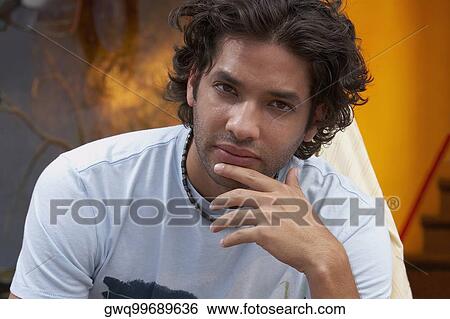 Portrait of a young man with his hand on his chin View Large Photo Image Stock Photograph - Portrait of a young man with his hand on his chin. Fotosearch