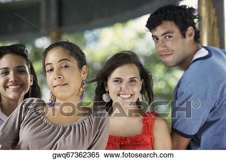 Portrait of a young man with three young women posing and smiling View Large Photo Image Stock Photography - Portrait of a young man with three young women posing and smiling. Fotosearch