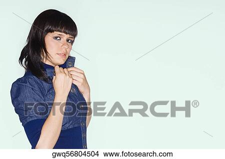 Picture - Portrait of a young woman adjusting her collar. Fotosearch