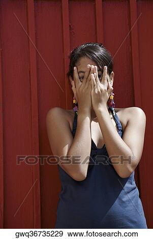 Portrait of a young woman covering her face with her hands View Large Photo Image Stock Photo - Portrait of a young woman covering her face with her hands. Fotosearch