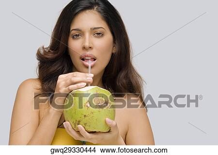 Portrait of a young woman drinking coconut milk View Large Photo Image Picture - Portrait of a young woman drinking coconut milk. Fotosearch