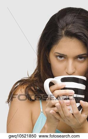 Portrait of a young woman drinking coffee View Large Photo Image Stock Image - Portrait of a young woman drinking coffee. Fotosearch