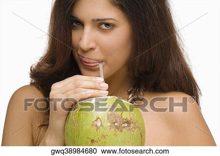 Stock Image - Portrait of a young woman drinking coconut milk. Fotosearch