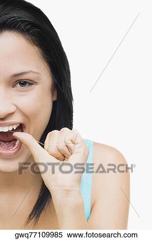 Portrait of a young woman flossing her teeth View Large Photo Image Stock Photography - Portrait of a young woman flossing her teeth. Fotosearch