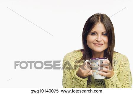 Stock Photography - Portrait of a young woman holding a cup of coffee and smiling. Fotosearch