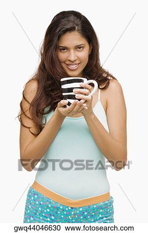 Portrait of a young woman holding a mug of coffee and smiling View Large Photo Image Stock Image - Portrait of a young woman holding a mug of coffee and smiling. Fotosearch