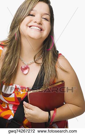 Stock Image - Portrait of a young woman holding a diary and smiling. Fotosearch