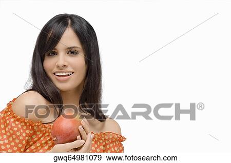 Portrait of a young woman holding a mango and smiling View Large Photo Image Stock Photo - Portrait of a young woman holding a mango and smiling. Fotosearch