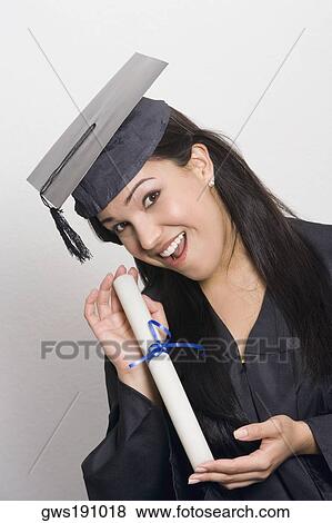 Portrait of a young woman holding a diploma and smiling View Large Photo Image Stock Photo - Portrait of a young woman holding a diploma and smiling. Fotosearch