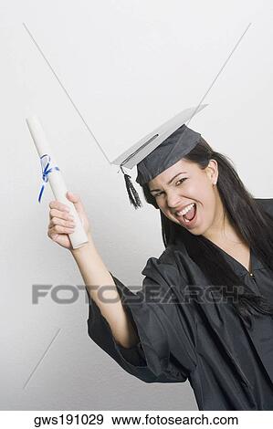 Portrait of a young woman holding a diploma and smiling View Large Photo Image Stock Photo - Portrait of a young woman holding a diploma and smiling. Fotosearch