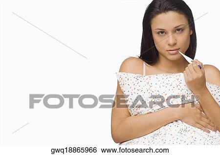 Portrait of a young woman holding a digital thermometer View Large Photo Image Stock Photograph - Portrait of a young woman holding a digital thermometer. Fotosearch