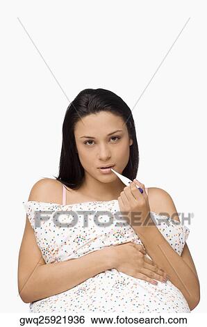 Portrait of a young woman holding a digital thermometer View Large Photo Image Stock Photograph - Portrait of a young woman holding a digital thermometer. Fotosearch