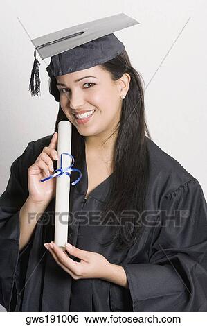 Portrait of a young woman holding a diploma and smiling View Large Photo Image Stock Photograph - Portrait of a young woman holding a diploma and smiling. Fotosearch