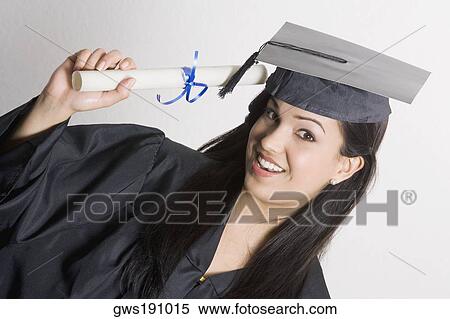 Stock Photography - Portrait of a young woman holding a diploma and smiling. Fotosearch