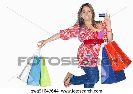 Portrait of a young woman holding shopping bags and dancing View Large Photo Image Picture - Portrait of a young woman holding shopping bags and dancing. Fotosearch