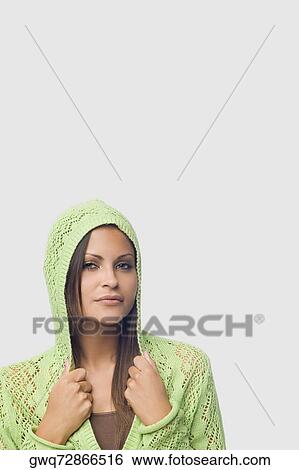 Portrait of a young woman holding collars of her hooded shirt View Large Photo Image Stock Photograph - Portrait of a young woman holding collars of her hooded shirt. Fotosearch