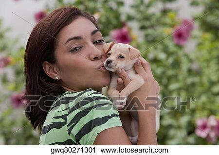 Portrait of a young woman kissing a puppy View Large Photo Image Stock Image - Portrait of a young woman kissing a puppy. Fotosearch