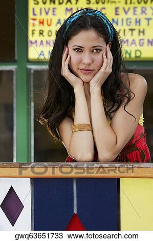 Portrait of a young woman leaning on a railing View Large Photo Image Stock Image - Portrait of a young woman leaning on a railing. Fotosearch