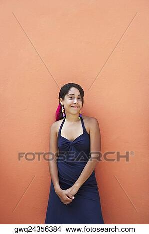 Portrait of a young woman leaning against a wall View Large Photo Image Picture - Portrait of a young woman leaning against a wall. Fotosearch