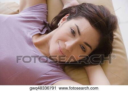 Portrait of a young woman lying on a couch and smiling View Large Photo Image Stock Image - Portrait of a young woman lying on a couch and smiling. Fotosearch
