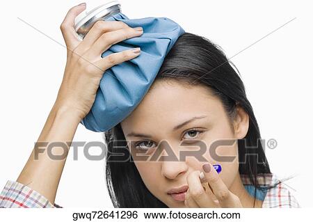 Portrait of a young woman measuring her temperature with a thermometer and holding an ice pack on her head View Large Photo Image Stock Photograph - Portrait of a young woman measuring her temperature with a thermometer and holding an ice pack on her head. Fotosearch