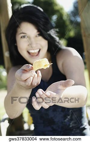 Portrait of a young woman offering an ice candy View Large Photo Image Picture - Portrait of a young woman offering an ice candy. Fotosearch
