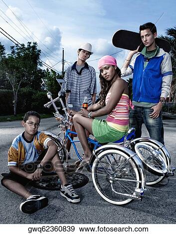 Portrait of a young woman on a low rider bicycle with her three friends beside her View Large Photo Image Stock Photo - Portrait of a young woman on a low rider bicycle with her three friends beside her. Fotosearch