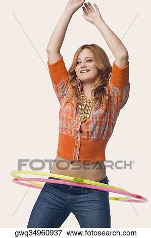 Stock Photo - Portrait of a young woman playing with a hula hoop. Fotosearch