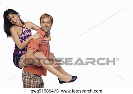 Stock Image - Portrait of a young woman riding piggyback on a mid adult man. Fotosearch