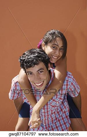 Portrait of a young woman riding piggyback on a young man View Large Photo Image Stock Photo - Portrait of a young woman riding piggyback on a young man. Fotosearch