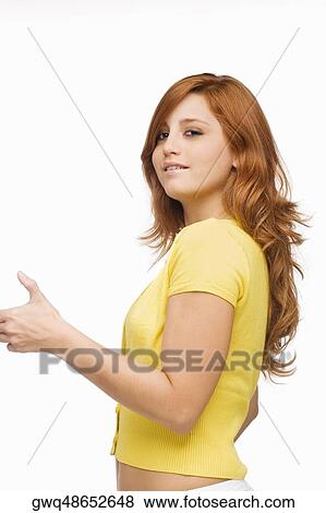 Portrait of a young woman showing a thumbs up sign and smiling View Large Photo Image Stock Photo - Portrait of a young woman showing a thumbs up sign and smiling. Fotosearch