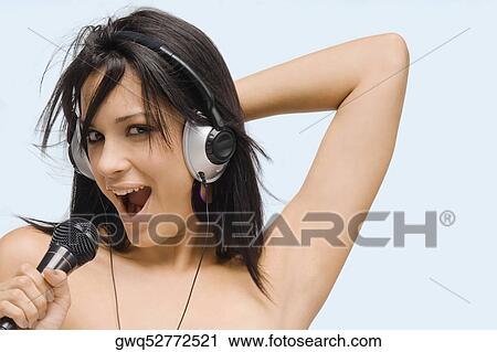 Portrait of a young woman singing into a microphone View Large Photo Image Stock Image - Portrait of a young woman singing into a microphone. Fotosearch