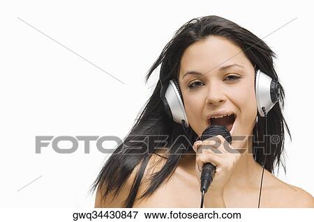 Stock Photo - Portrait of a young woman singing into a microphone. Fotosearch