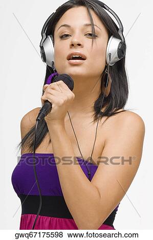 Portrait of a young woman singing into a microphone View Large Photo Image Stock Photo - Portrait of a young woman singing into a microphone. Fotosearch
