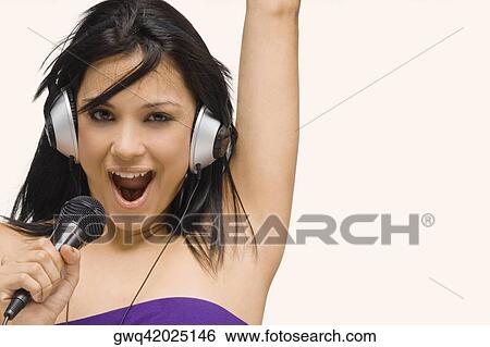 Portrait of a young woman singing into a microphone View Large Photo Image Stock Photograph - Portrait of a young woman singing into a microphone. Fotosearch