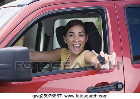 Portrait of a young woman sitting in a car and showing a car key View Large Photo Image Stock Photo - Portrait of a young woman sitting in a car and showing a car key. Fotosearch