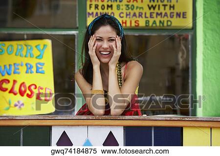 Stock Photography - Portrait of a young woman smiling and leaning on a railing. Fotosearch