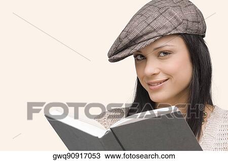 Portrait of a young woman smiling with a book in front of her View Large Photo Image Stock Image - Portrait of a young woman smiling with a book in front of her. Fotosearch